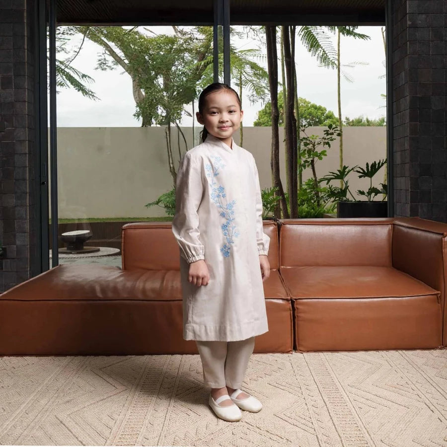 Child in a white tunic by Jenna & Kaia standing in front of a brown leather sofa with a garden view.

Seorang anak mengenakan tunik putih karya Jenna & Kaia berdiri di depan sofa kulit cokelat dengan pemandangan taman.
