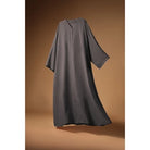 Gray Mecca Dhurma Abaya by Nehhat Modest on a brown background