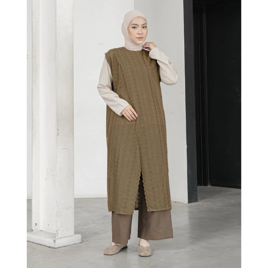Woman wearing a long brown textured vest by Mistyvori with a white hijab indoors.