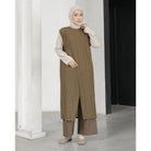 Woman wearing a long brown textured vest by Mistyvori with a white hijab indoors.