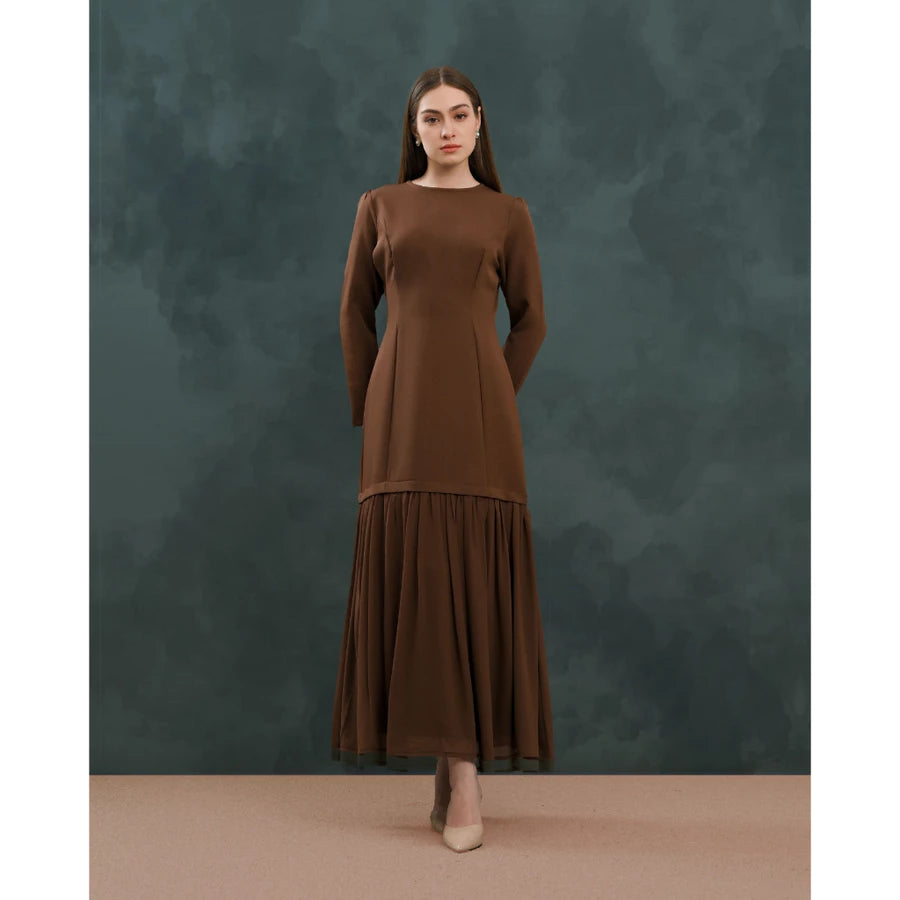 Woman wearing a brown dress by Kasa Heritage against a dark green background