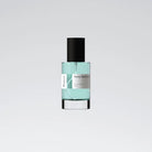 Perfume bottle with a black cap and light blue liquid from Boura on a gray background