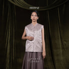 Woman wearing a taupe-colored sleeveless embroidered vest and skirt with 'BWBYAZ' branding.