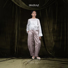 Model wearing a white top and light brown barrel pants against a dark curtain backdrop with 'BWBYAZ' branding.