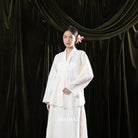 Woman in a cream traditional dress standing against a dark green curtain with 'BWBYAZ' branding.

Seorang wanita mengenakan kebaya berwarna krem berdiri di depan tirai hijau gelap dengan merek ‘BWBYAZ.