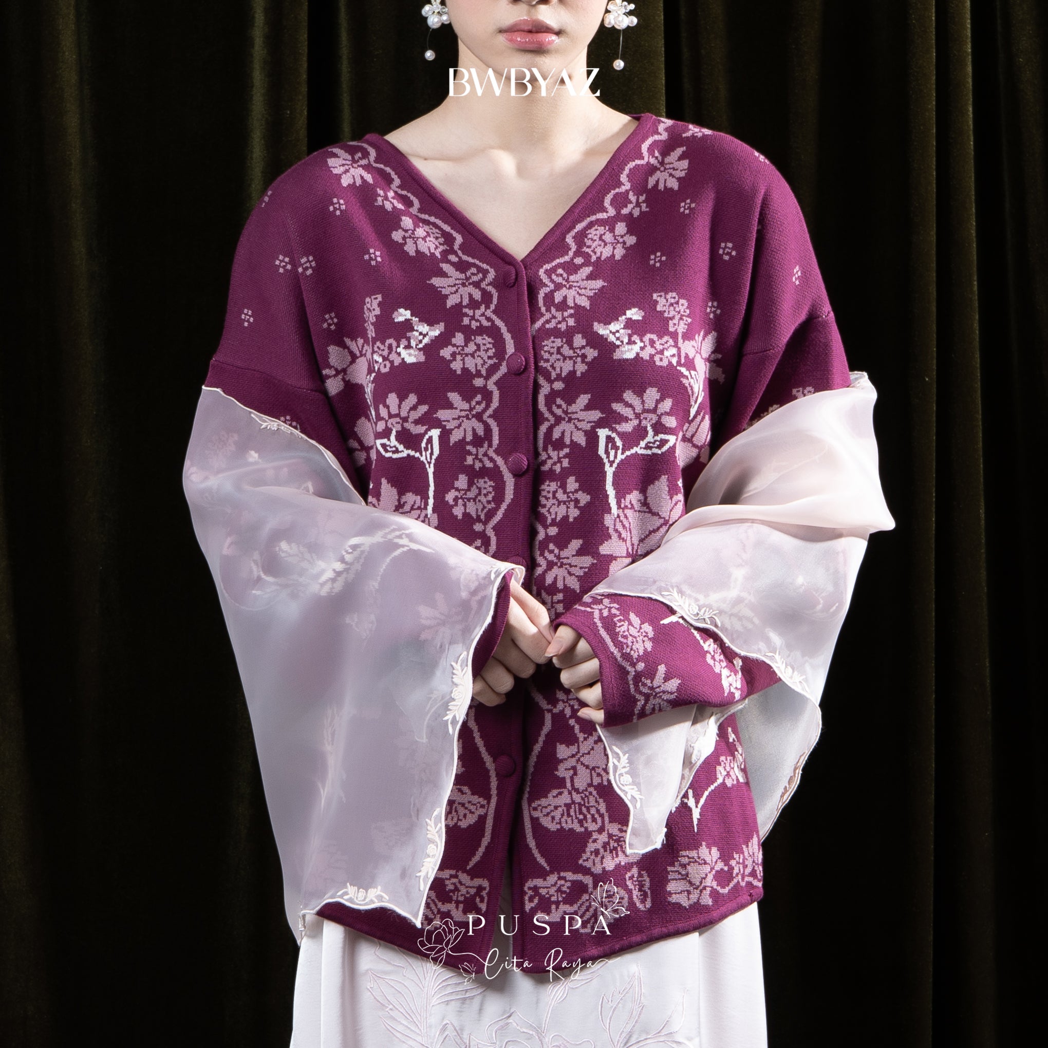 Person wearing a maroon floral cardigan by BWBYAZ against a dark background