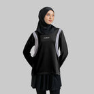 A woman wearing a black activewear top with the brand name 'noore' on the front, paired with a black headscarf.