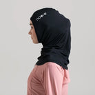 A woman wearing a black headscarf with the brand 'noore' visible on the front