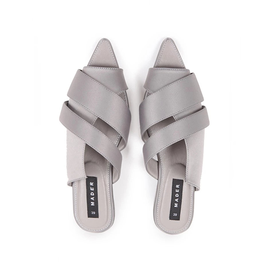 A pair of gray open toe mules with double strap and low heel.