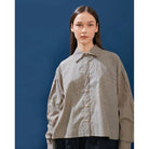 Person wearing a brown striped shirt by Yestoday against a blue background