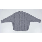 Black and white mini checkered oversized shirt by Yestoday with button details on a light gray background