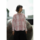 Person wearing a red and white checkered shirt by Yestoday standing in front of a large spherical object.