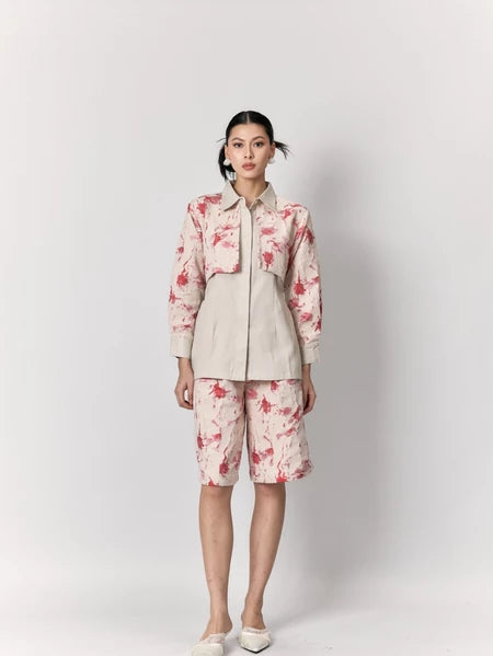 Woman wearing a floral pink shirt by Studio Tui on a white background