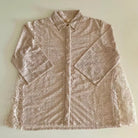 Nude-colored lace blouse by Holy Peony on a light beige background