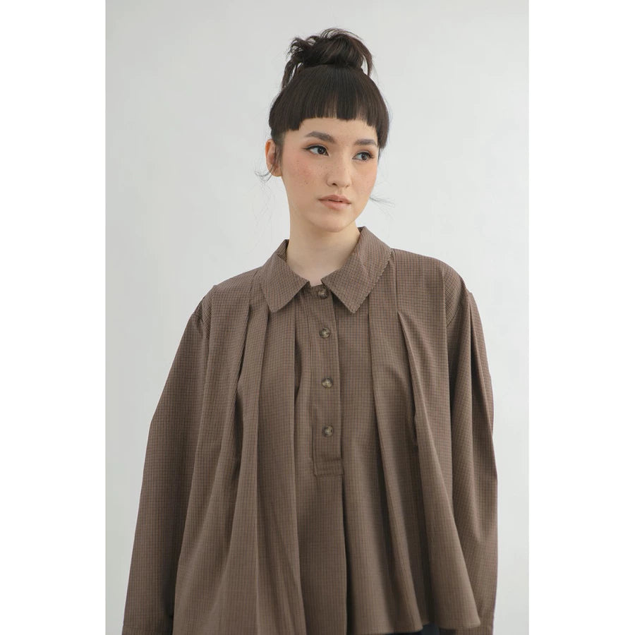 Person wearing a brown checkered blouse by Yestoday against a white background