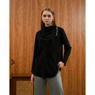 Woman wearing a black Rachel Blouse by Kasa Heritage with pearl details against a wooden background