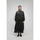 Person wearing a black oversized dress by Yestoday with sheer overlay on a gray background