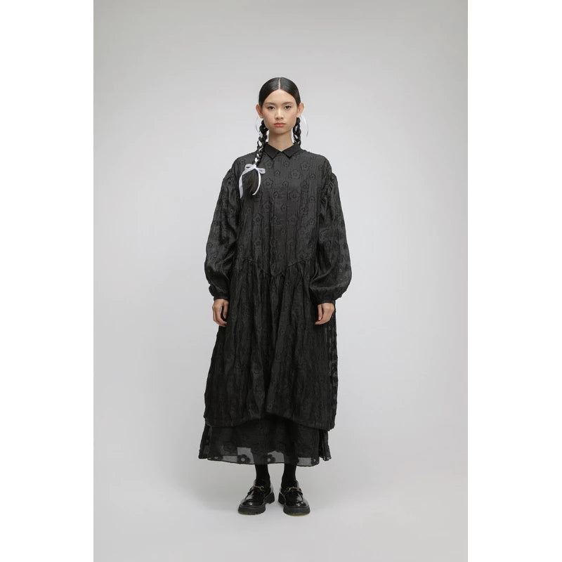 Person wearing a black oversized dress by Yestoday with sheer overlay on a gray background