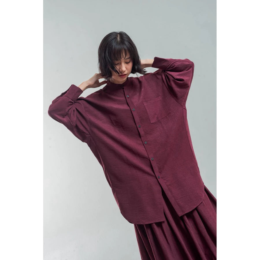 Woman wearing a burgundy oversized shirt by Yestoday against a plain background