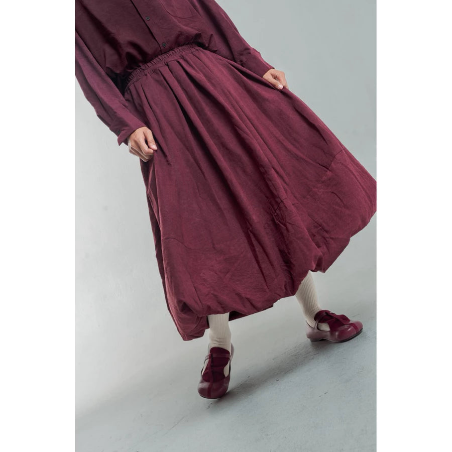 Person wearing a burgundy skirt by Yestoday on a plain background