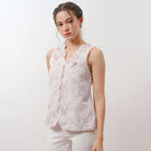 Woman wearing a light pink floral sleeveless vest by Holy Peony against a white background