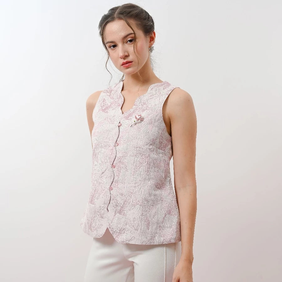 Woman wearing a light pink floral sleeveless vest by Holy Peony against a white background