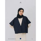 Person wearing a navy linen double-button vest by Swifter over a beige shirt with a plain background