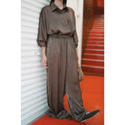 Person wearing a brown top and culottes standing against a white wall with a red floor.

Seorang wanita mengenakan atasan cokelat dan celana kulot sedang berdiri di depan dinding putih dengan lantai berwarna merah.