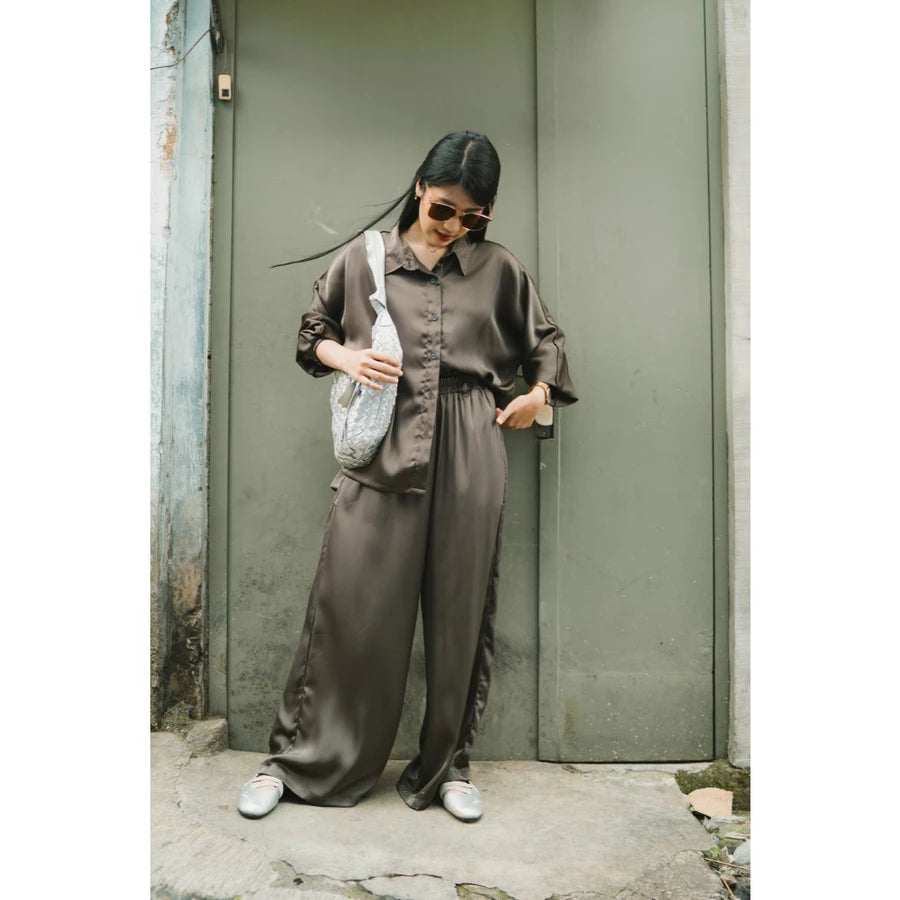 Woman in a brown top and culottes standing against a green wall.

Seorang wanita mengenakan atasan cokelat dan celana kulot sedang berdiri di depan dinding hijau.