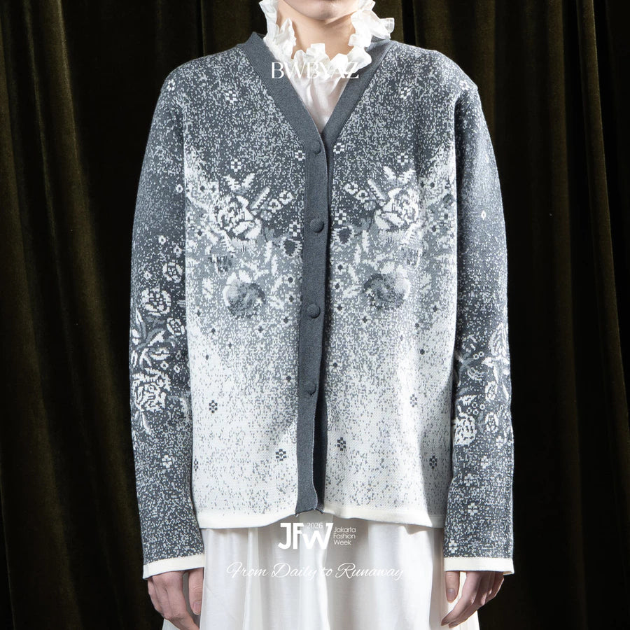 Person wearing a grey patterned cardigan by BWBYAZ over a white shirt with a dark background