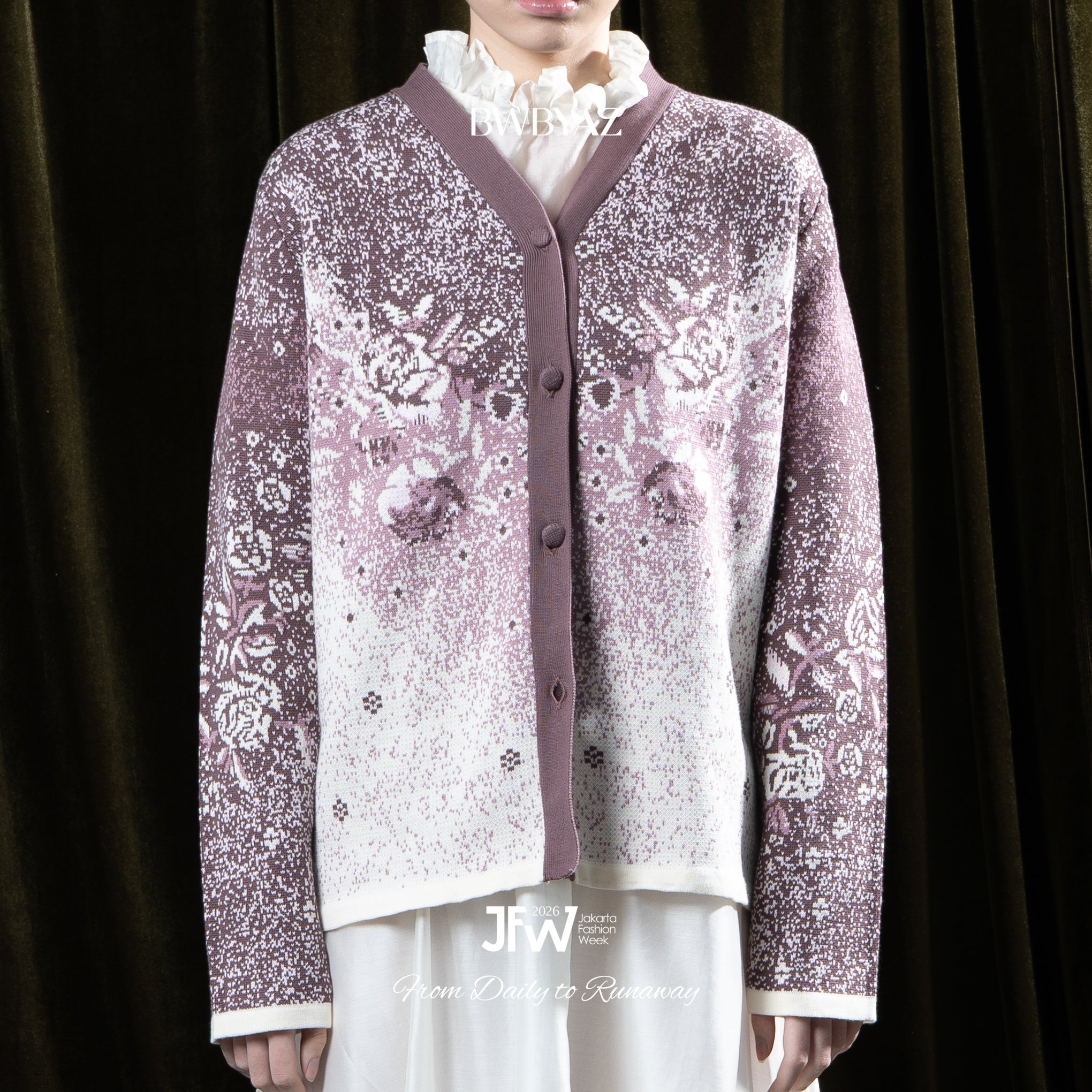 Person wearing a purple patterned cardigan by BWBYAZ over a white shirt against a dark background