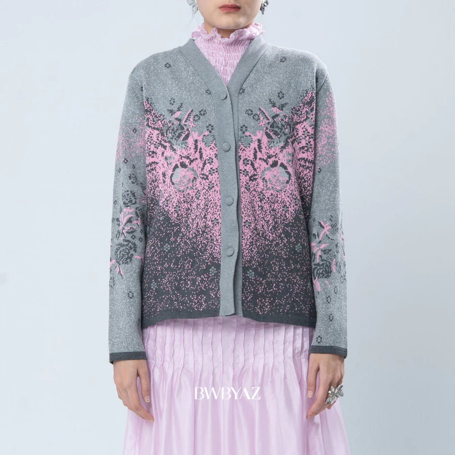 Person wearing a gray cardigan with pink floral patterns by BWBYAZ on a light blue background