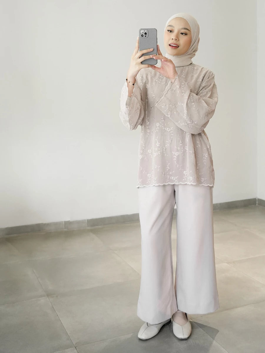 Person wearing a broken white floral blouse by Mistyvori with a hijab, standing in a room.