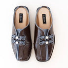 Pair of brown mules flats by Dianable with decorative elements on a white background
