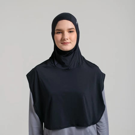 Person wearing a black sport hijab by Noore and gray shirt on a light gray background