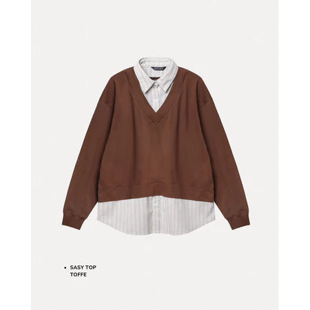 Brown sweater with white shirt underneath on a light gray background