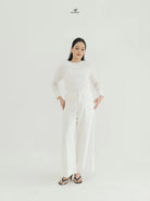 Person wearing a white top and wide-leg pants by Swifter with a brand logo on a white background