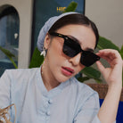 Woman wearing sunglasses by HSF Eyewear with a blurred background