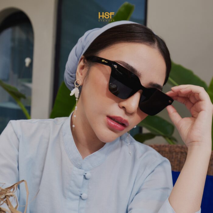 Woman wearing sunglasses by HSF Eyewear with a blurred background