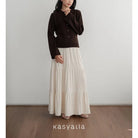 Person wearing a brown top and white skirt with 'kasyalia' branding.