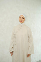 Woman wearing a white hijab and ivory-colored tunic by Tufine against a white background

Seorang wanita yang mengenakan hijab putih dan tunik berwarna krem dari Tufine dengan latar belakang putih