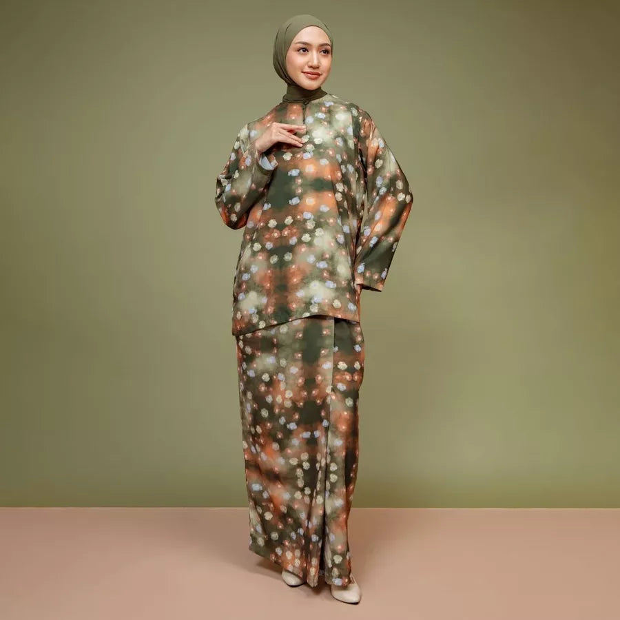 Woman wearing a patterned tunic set by Lozy Hijab against a green background.

Seorang wanita mengenakan set tunik bermotif dari Lozy Hijab dengan latar belakang hijau.