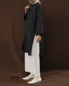 Person wearing a black tunic by Mistyvori over a white outfit on a brown background.

Seorang wanita mengenakan tunik hitam dari Mistyvori di atas pakaian putih dengan latar belakang cokelat.