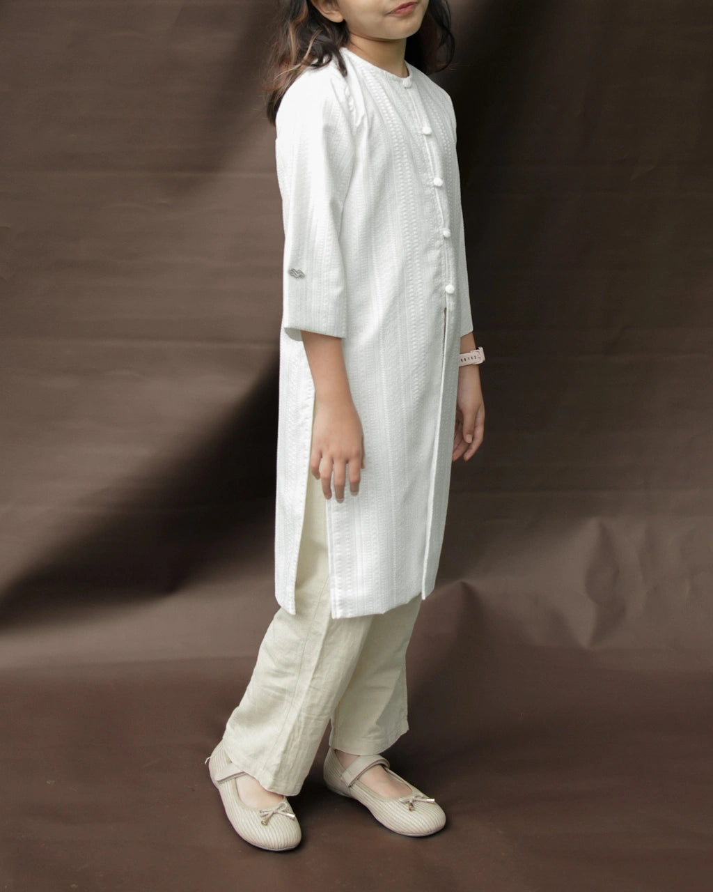 Child wearing a white tunic by Mistyvori with beige pants on a brown background.

Seorang anak mengenakan tunik putih dari Mistyvori dengan celana krem di atas latar belakang cokelat.