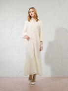 Woman wearing a long, light ivory-colored dress by Kasa Heritage against a white background