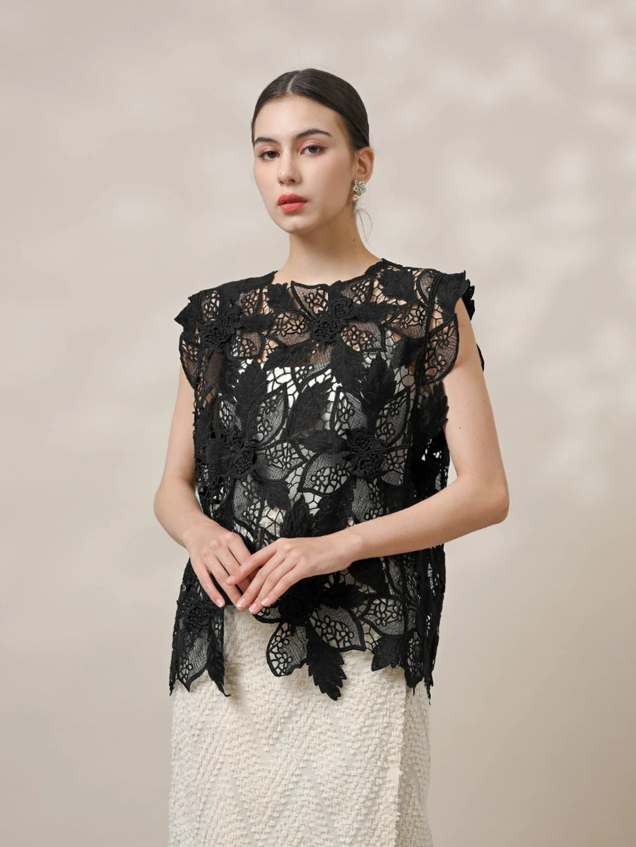 Woman wearing a black lace vest by Kasa Heritage against a beige background