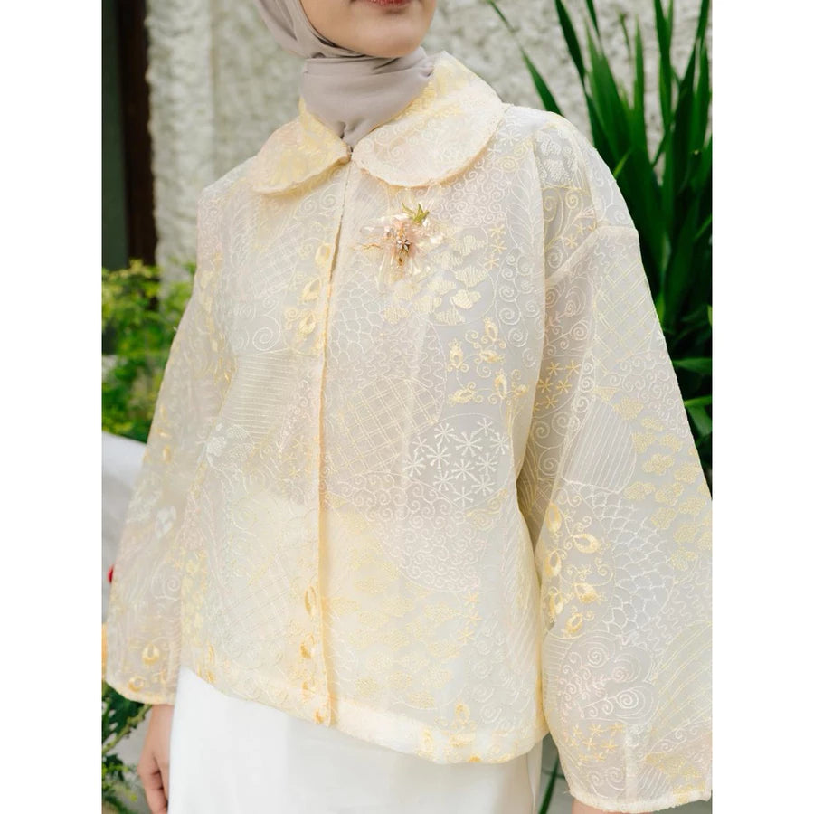 Woman wearing a yellow lace outer with floral details by Haidee Orlin in an outdoor setting.