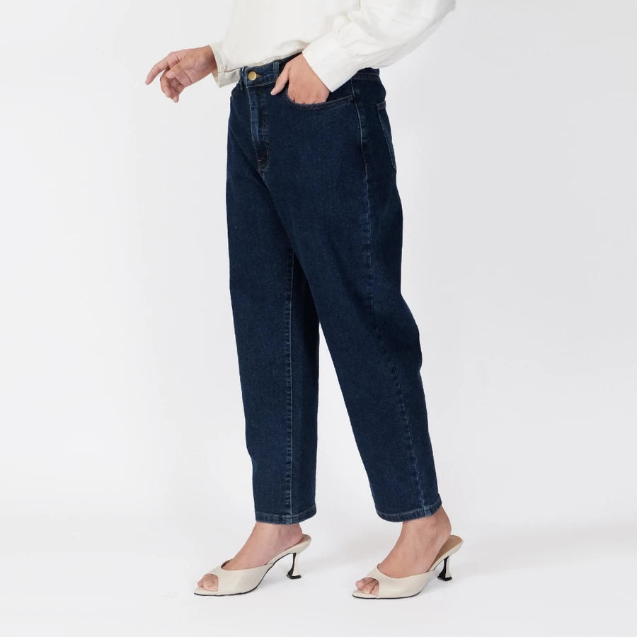 A model wearing dark wash blue denim pants, a white long-sleeve blouse, and white slingback kitten heels, shown from the waist down against a plain white studio background.

Seorang model mengenakan celana denim biru dengan warna gelap, blus lengan panjang berwarna putih, dan sepatu kitten heels slingback putih, difoto dari pinggang ke bawah dengan latar belakang studio berwarna putih polos.