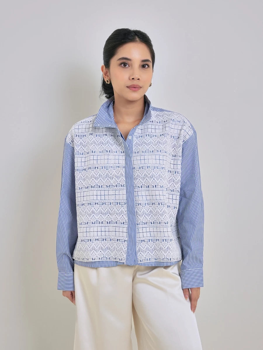 Woman wearing a blue and white patterned shirt by Studio Tui against a plain background