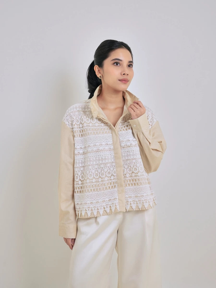 Woman wearing a cream and white patterned shirt by Studio Tui against a plain background